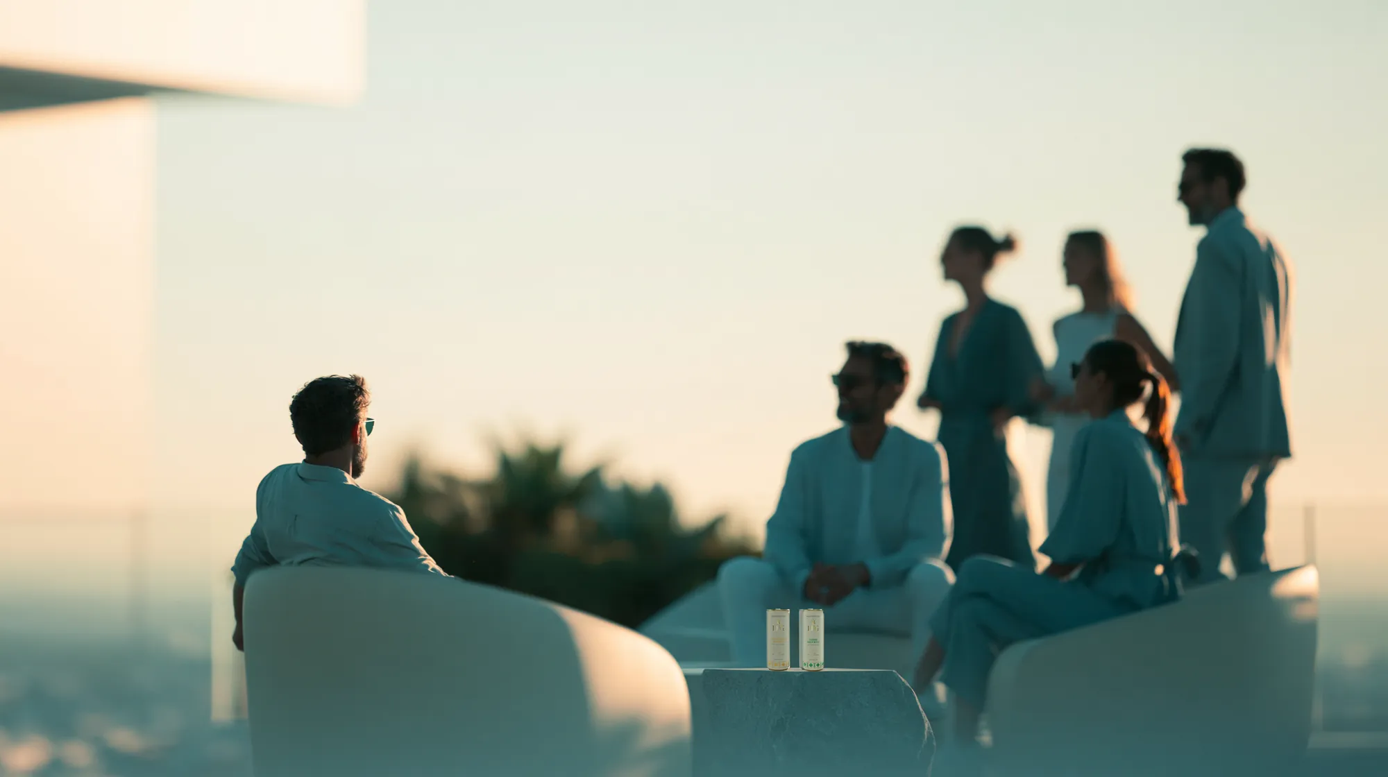 Friends on a rooftop terrace at sunset with LFG cans